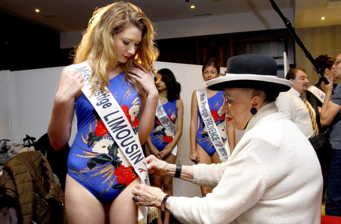 La présidente d'honneur de Miss Prestige National épingle les écharpes des concurrentes